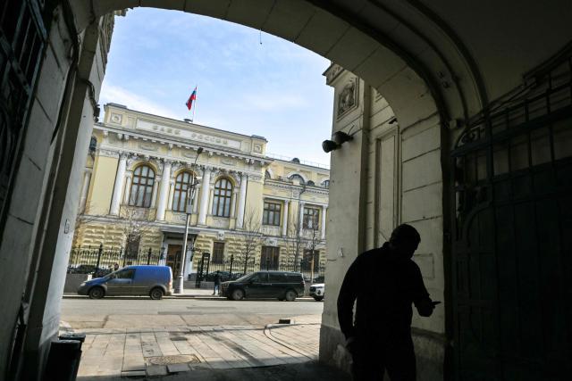 A man walks past the Russian Central Bank headquarters in Neglinnaya street in central Moscow on March 20, 2026. Russia's central bank on March 20, 2026 cut its key interest rate to 15 percent from 15.5 percent as the economy slows under pressure from Moscow's protracted and expensive war in Ukraine and Western sanctions. (Photo by Igor IVANKO / AFP)