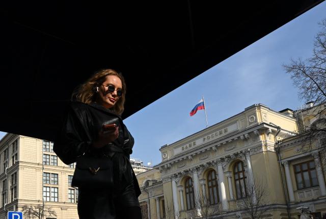 A woman walks past the Russian Central Bank headquarters in Neglinnaya street in central Moscow on March 20, 2026. Russia's central bank on March 20, 2026 cut its key interest rate to 15 percent from 15.5 percent as the economy slows under pressure from Moscow's protracted and expensive war in Ukraine and Western sanctions. (Photo by Igor IVANKO / AFP)