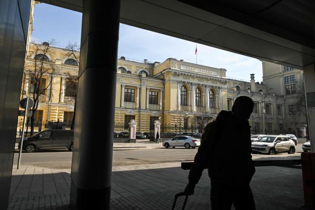 A man walks past the Russian Central Bank headquarters in Neglinnaya street in central Moscow on March 20, 2026. Russia's central bank on March 20, 2026 cut its key interest rate to 15 percent from 15.5 percent as the economy slows under pressure from Moscow's protracted and expensive war in Ukraine and Western sanctions. (Photo by Igor IVANKO / AFP)
