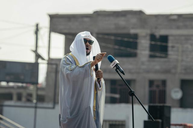 A Muslim sheikh delivers a sermon during a gathering where Muslim devotees offer Eid al-Fitr prayers, marking the end of the holy month of Ramadan, at Unity Stadium in Goma on March 20, 2026. (Photo by Jospin Mwisha / AFP)