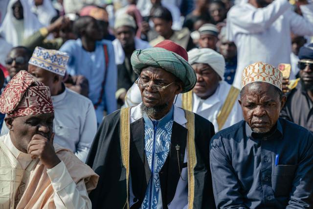 Muslim devotees listen as a Muslim sheikh delivers a sermon during a gathering for Eid al-Fitr prayers, marking the end of the holy month of Ramadan, at Unity Stadium in Goma on March 20, 2026. (Photo by Jospin Mwisha / AFP)