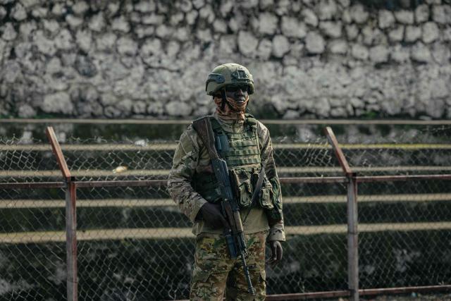 A M23 soldier stands guard as Muslim devotees offer Eid al-Fitr prayers, marking the end of the holy month of Ramadan, at Unity Stadium in Goma on March 20, 2026. (Photo by Jospin Mwisha / AFP)
