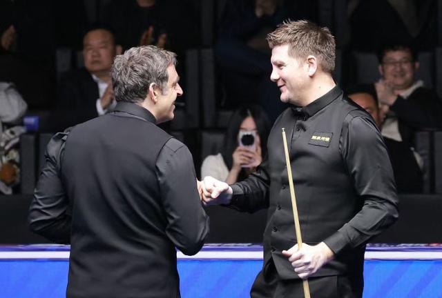 Britain's Ronnie O'Sullivan (L) is congratulated by Ryan Day of Wales after O’Sullivan made professional snooker history with the highest ever break of 153 during their match at the Snooker World Open in Yushan, in China’s Jiangxi province on March 20, 2026. (Photo by CN-STR / AFP) / China OUT