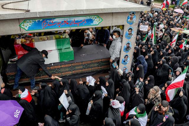 TOPSHOT - Mourners bid farewell to the bodies of Iran's slain intelligence minister Esmail Khatib and his family during their funeral after the weekly Friday noon prayers in Tehran on March 20, 2026. Israel's military said on March 18 that it would not stop its "series of eliminations" of senior Iranian officials, after announcing it had killed Khatib. His killing came soon after Israel killed Iran's powerful security chief Ali Larijani. (Photo by AFP)