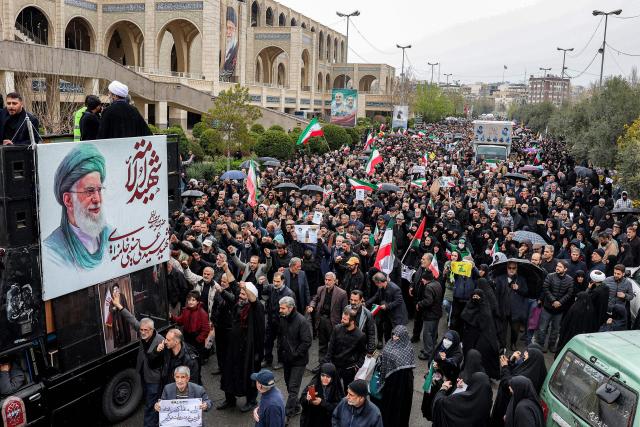 Mourners march during the funeral ceremony for Iran's slain intelligence minister Esmail Khatib and his family after the weekly Friday Muslim noon prayers in Tehran on March 20, 2026. Israel's military said on March 18 that it would not stop its "series of eliminations" of senior Iranian officials, after announcing it had killed Khatib. His killing came soon after Israel killed Iran's powerful security chief Ali Larijani. (Photo by AFP)