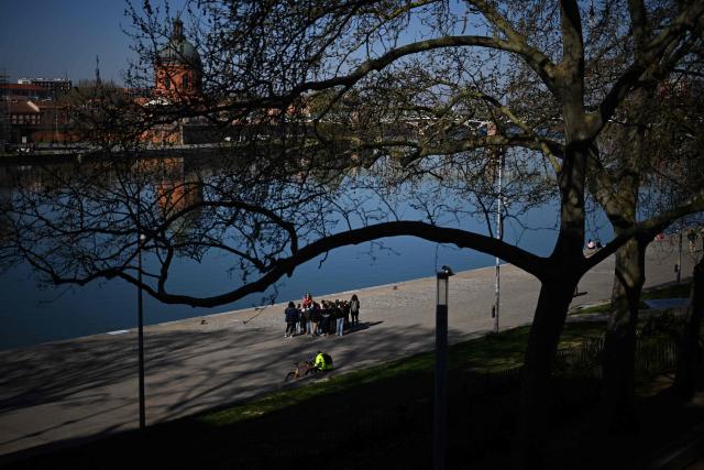Children and their teacher gather on the banks of the River Garonne in Toulouse, southern France, on March 20, 2026. (Photo by Lionel BONAVENTURE / AFP)
