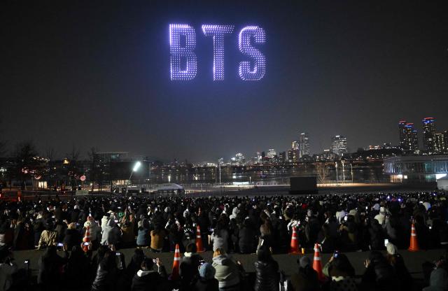 Drones illuminate the night sky with BTS logo during a drone light show at a riverside park in Seoul on March 20, 2026, ahead of the comeback concert of K-pop boy band BTS. K-pop megastars BTS released a new album on March 20, as buzz built ahead of their open-air comeback concert in Seoul that will go ahead despite leader RM being advised to rest his injured ankle. (Photo by Jung Yeon-je / AFP)