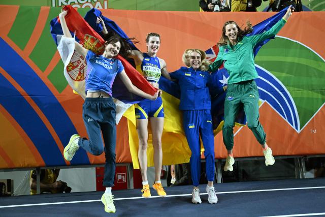 Gold medallist Ukraine's Yaroslava Mahuchikh (2ndL) celebrates with silver medallists Serbia's Angelina Topic (L), Ukraine's Yuliia Levchenko and Australia's Nicola Olyslagers after the women's final high jump event during the World Athletics Indoor Championships Kujawy Pomorze 2026 in Torun, Poland on March 20, 2026. (Photo by Kirill KUDRYAVTSEV / AFP)