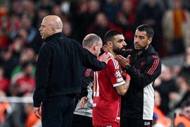 (FILES) Liverpool's Egyptian forward #11 Mohamed Salah (C) is greeted by Liverpool's Dutch coach Arne Slot (L) after being substituted during the UEFA Champions League, round of 16 second leg football match between Liverpool and Galatasaray at Anfield in Liverpool, north-west England on March 18, 2026. Mohamed Salah will miss Liverpool's trip to Brighton on Saturday with a muscle injury -- a major blow for manager Arne Slot as he hunts a Champions League place next season. (Photo by Paul ELLIS / AFP)