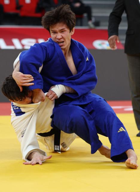 Israel's Izhak Ashpiz (white) competes against Russia's Achyty Dombuu in the men's under 60 kg final bout at the Tbilisi Grand Slam judo tournament in Tbilisi on March 20, 2026. (Photo by Giorgi ARJEVANIDZE / AFP)