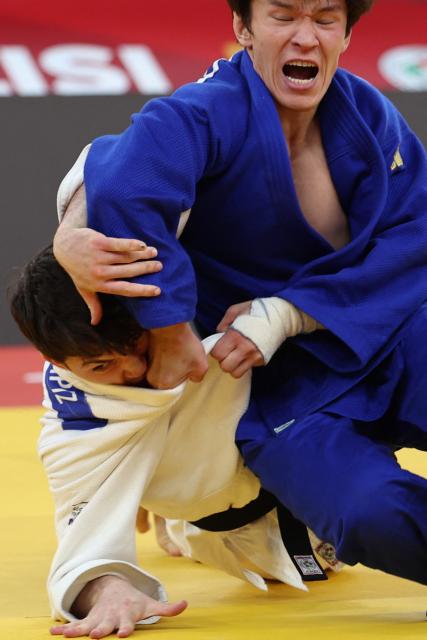 Israel's Izhak Ashpiz (white) competes against Russia's Achyty Dombuu in the men's under 60 kg final bout at the Tbilisi Grand Slam judo tournament in Tbilisi on March 20, 2026. (Photo by Giorgi ARJEVANIDZE / AFP)