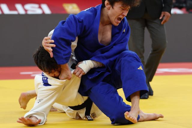 Israel's Izhak Ashpiz (white) competes against Russia's Achyty Dombuu in the men's under 60 kg final bout at the Tbilisi Grand Slam judo tournament in Tbilisi on March 20, 2026. (Photo by Giorgi ARJEVANIDZE / AFP)