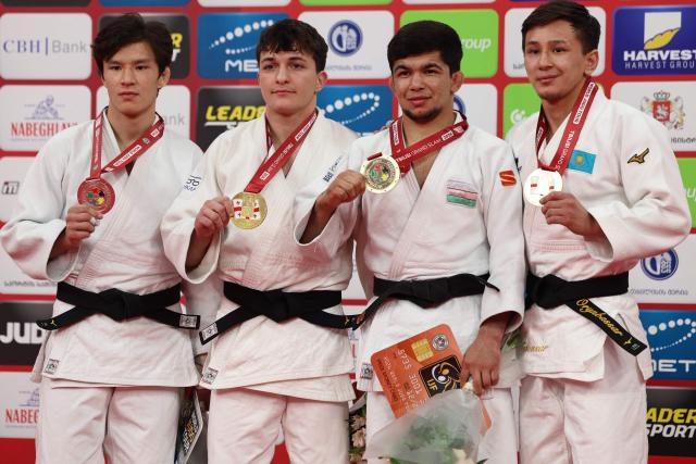 Silver medallist Russia's Achyty Dombuu, gold medallist Israel's Izhak Ashpiz and bronze medallists Uzbekistan's Samariddin Kuchkarov and Kazakhstan's Talgat Orynbassar pose with their medals during a ceremony for the men's under 60 kg event at the Tbilisi Grand Slam judo tournament in Tbilisi on March 20, 2026. (Photo by Giorgi ARJEVANIDZE / AFP)