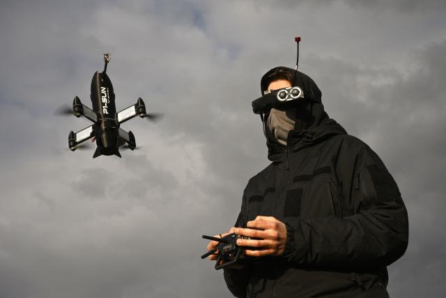 TOPSHOT - An employee of the Ukrainian SkyFall company conducts a test flight with a P1-Sun interceptor drone at an undisclosed location in Ukraine on March 19, 2026, amid the Russian invasion of Ukraine. (Photo by Genya SAVILOV / AFP)