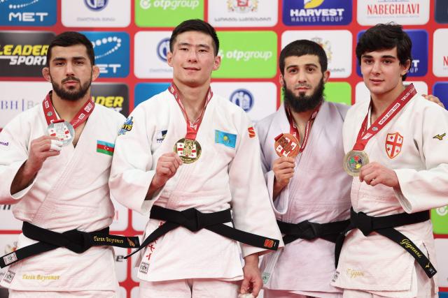 Silver medallist Azerbaijan's Turan Bayramov, gold medallist Kazakhstan's Nurkanat Serikbayev and bronze medallists Russia's Ramazan Abdulaev and Georgia's Tornike Gigauri pose with their medals during a ceremony for the men's under 66 kg event at the Tbilisi Grand Slam judo tournament in Tbilisi on March 20, 2026. (Photo by Giorgi ARJEVANIDZE / AFP)