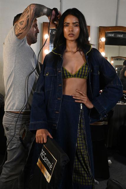 A model prepares backstage at the Lakme Fashion Week (LFW) in Mumbai on March 20, 2026. (Photo by SUJIT JAISWAL / AFP)