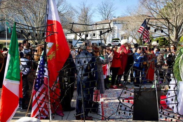 Placards bearing the names of victims killed during the deadly crackdown on protests in Iran on January 89, 2026 are displayed as local Iranian residents gather outside the former Embassy of Iran to mark the Persian New Year, Nowruz, at the moment of the new year on March 20, 2026, in Washington, DC. Iranian families in the Washington, DC, area are trying to maintain cultural traditions while following the news of the ongoing conflict in Iran. From specialty Persian markets to community gatherings, preparations continue with a mix of resilience and concern, as the diaspora balances celebration with anxiety for loved ones in a country facing escalating violence. (Photo by Amid FARAHI / AFP)