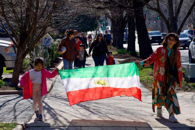 Iranian residents of Washington, DC, gather outside the former Embassy of Iran to mark the Persian New Year, Nowruz, at the moment of the new year on March 20, 2026, in Washington, DC. Iranian families in the Washington, DC, area are trying to maintain cultural traditions while following the news of the ongoing conflict in Iran. From specialty Persian markets to community gatherings, preparations continue with a mix of resilience and concern, as the diaspora balances celebration with anxiety for loved ones in a country facing escalating violence. (Photo by Amid FARAHI / AFP)