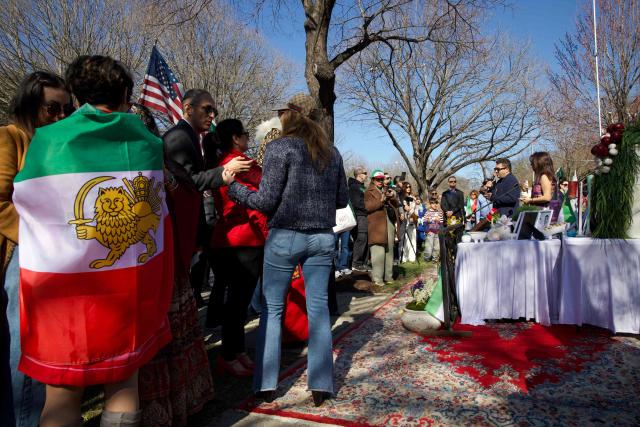 Iranian residents of Washington, DC, gather outside the former Embassy of Iran to mark the Persian New Year, Nowruz, at the moment of the new year on March 20, 2026, in Washington, DC. Iranian families in the Washington, DC, area are trying to maintain cultural traditions while following the news of the ongoing conflict in Iran. From specialty Persian markets to community gatherings, preparations continue with a mix of resilience and concern, as the diaspora balances celebration with anxiety for loved ones in a country facing escalating violence. (Photo by Amid FARAHI / AFP)