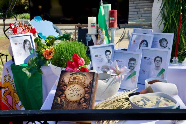 A Nowruz Haft Sin table arranged by local Iranian residents has elements dedicated to the memory of victims killed during the deadly crackdown on protests in Iran on January 89, 2026, as local Iranians gather outside the former Embassy of Iran to mark the Persian New Year, Nowruz, at the moment of the new year on March 20, 2026, in Washington, DC. Iranian families in the Washington, DC, area are trying to maintain cultural traditions while following the news of the ongoing conflict in Iran. From specialty Persian markets to community gatherings, preparations continue with a mix of resilience and concern, as the diaspora balances celebration with anxiety for loved ones in a country facing escalating violence. (Photo by Amid FARAHI / AFP)