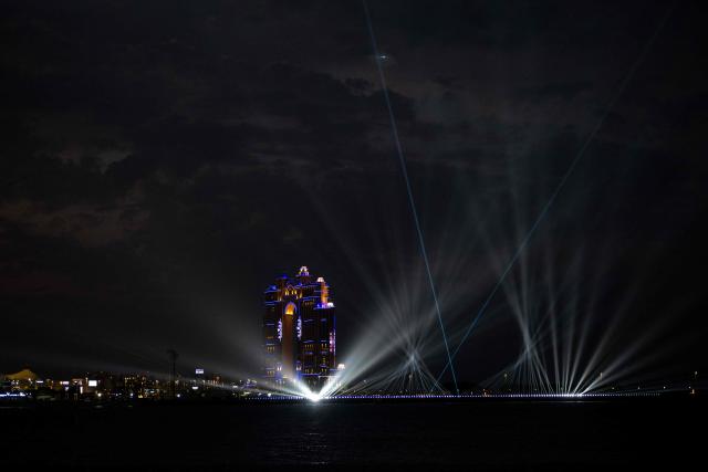 A laser and light show lights up the sky to on Eid Al-Fitr, marking the end of the holy month of Ramadan, along the Corniche in Abu Dhabi on March 20, 2026. For many Muslim-majority countries in the Middle East, Eid al-Fitr has fallen with the outbreak of the war which began on February 28, when Israel and the US launched strikes on Iran, killing its supreme leader, and prompting retaliatory strikes from the Islamic Republic on Israel and across the Gulf. (Photo by Ryan Lim / AFP)