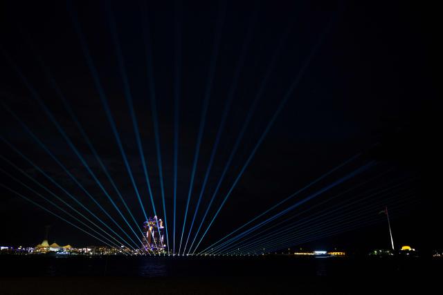 A laser and light show lights up the sky to on Eid Al-Fitr, marking the end of the holy month of Ramadan, along the Corniche in Abu Dhabi on March 20, 2026. For many Muslim-majority countries in the Middle East, Eid al-Fitr has fallen with the outbreak of the war which began on February 28, when Israel and the US launched strikes on Iran, killing its supreme leader, and prompting retaliatory strikes from the Islamic Republic on Israel and across the Gulf. (Photo by Ryan Lim / AFP)