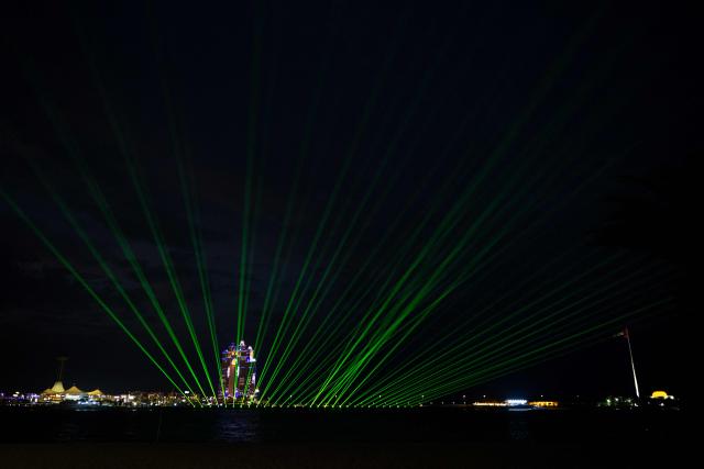 A laser and light show lights up the sky to on Eid Al-Fitr, marking the end of the holy month of Ramadan, along the Corniche in Abu Dhabi on March 20, 2026. For many Muslim-majority countries in the Middle East, Eid al-Fitr has fallen with the outbreak of the war which began on February 28, when Israel and the US launched strikes on Iran, killing its supreme leader, and prompting retaliatory strikes from the Islamic Republic on Israel and across the Gulf. (Photo by Ryan Lim / AFP)