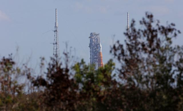 NASA's Artemis II Space Launch System (SLS) rocket and Orion spacecraft are seen at Launch Pad 39B at the Kennedy Space Center in Cape Canaveral, Florida on March 20, 2026. NASA on March 19 began returning its towering SLS rocket and Orion spacecraft to its Florida launch pad ahead of a planned flyby of the Moon, after completing necessary repairs. Artemis engineers began the maneuver, which can take up to 12 hours, at 8:00 pm eastern, after which the US space agency will begin final preparations before its next launch window opens on April 1. (Photo by Gregg Newton / AFP)