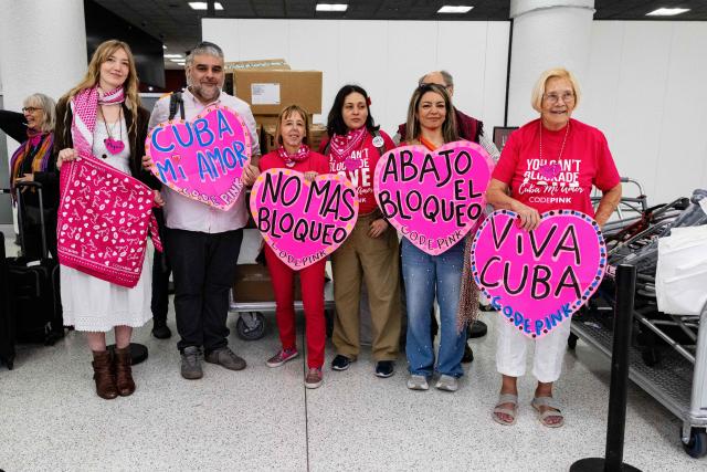 Members of the Nuestra America Convoy hold signs in support of Cuba as they pose for a photo before checking in at Miami International Airport in Miami, Florida, on March 20, 2026, ahead of the delegation traveling to Cuba with humanitarian aid. The group will bring 6,300 pounds of medicine and medical supplies to Cuba, who is experiencing shortages. Cuba has been mired in an economic crisis exacerbated by the sudden suspension of oil supplies from Venezuela in January after the United States ousted president Nicolas Maduro, a Cuba ally. (Photo by Eva Marie UZCATEGUI / AFP)