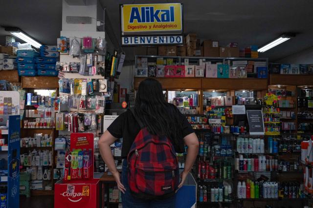 A woman buys a package of recreational cannabis for sale at a pharmacy in Montevideo on March 18, 2026. (Photo by Eitan ABRAMOVICH / AFP)