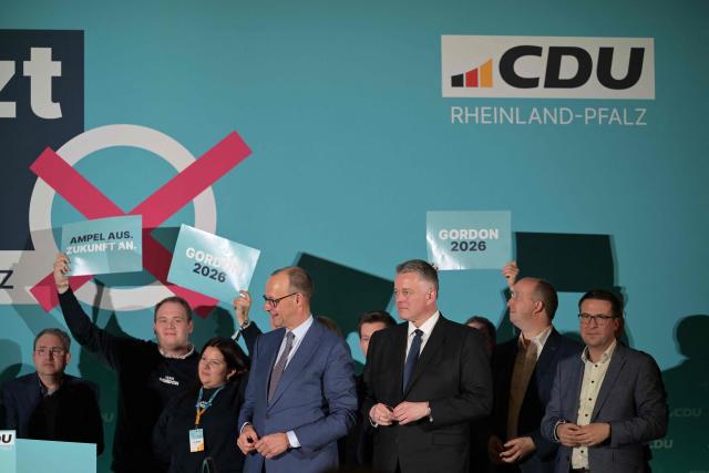 German Chancellor Friedrich Merz (C) and Gordon Schnieder (3rd R), Christian Democratic Union (CDU) top candidate in the State elections in Rhineland-Palatinate, are pictured on stage at the end of a campaign event in Bad Duerkheim, western Germany on March 22, 2026. (Photo by Hannes P. Albert / AFP)