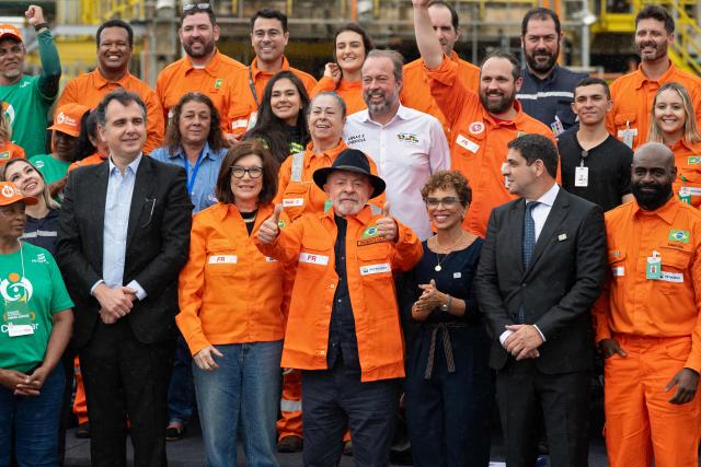 Brazilian President Luiz Inacio Lula da Silva (C) poses with Petrobras President Magda Chambriard (C-L), politicians and employees during an event to announce Petrobras' investments at the Gabriel Passos Refinery in Betim, Minas Gerais state, Brazil, on March 20, 2026. (Photo by Douglas MAGNO / AFP)