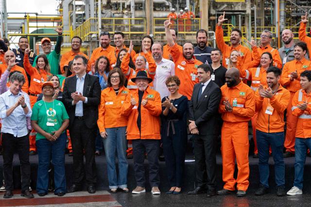 Brazilian President Luiz Inacio Lula da Silva (C) poses with Petrobras President Magda Chambriard (C-L), politicians and employees during an event to announce Petrobras' investments at the Gabriel Passos Refinery in Betim, Minas Gerais state, Brazil, on March 20, 2026. (Photo by Douglas MAGNO / AFP)