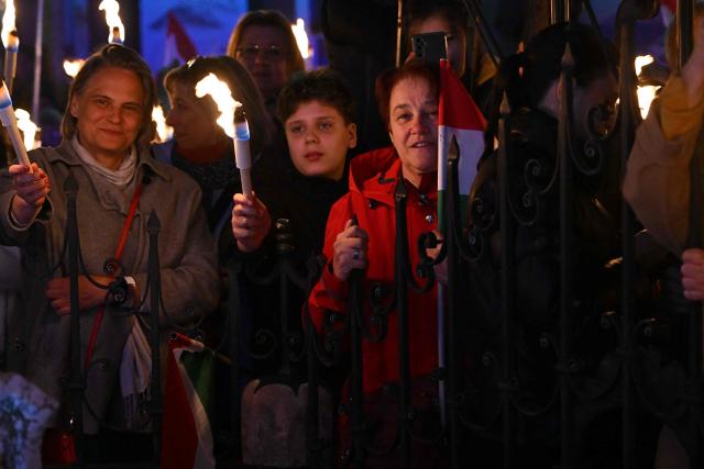 Supporters of Hungarian Prime Minister Viktor Orban hold torches as they listen to his speech at Szentendre town on March 20, 2026 as he continued his national campaign tour. Orban arrived directly from the Brussels EU summit to address supporters on key national issues in Szentendre, one of several stops on the Prime Minister’s nationwide tour ahead of the April parliamentary election. (Photo by Attila KISBENEDEK / AFP)