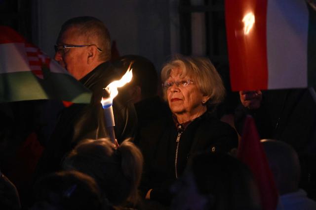 Supporters of Hungarian Prime Minister Viktor Orban hold torches as they listen to his speech at Szentendre town on March 20, 2026 as he continued his national campaign tour. Orban arrived directly from the Brussels EU summit to address supporters on key national issues in Szentendre, one of several stops on the Prime Minister’s nationwide tour ahead of the April parliamentary election. (Photo by Attila KISBENEDEK / AFP)