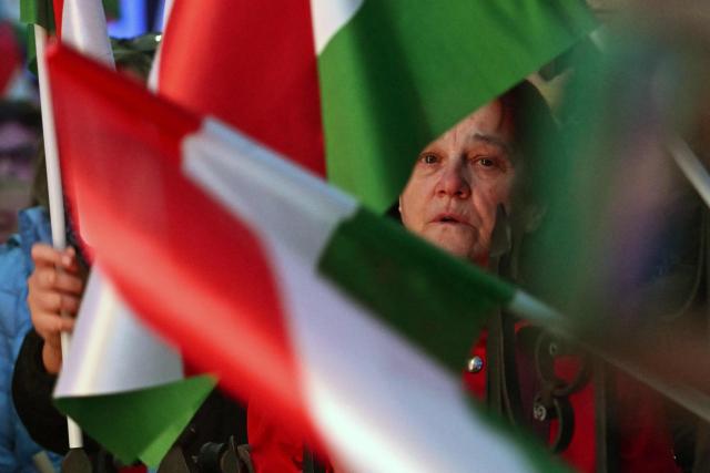 Supporters of Hungarian Prime Minister Viktor Orban hold Hurgarian flags as they listen to his speech at Szentendre town on March 20, 2026 as he continued his national campaign tour. Orban arrived directly from the Brussels EU summit to address supporters on key national issues in Szentendre, one of several stops on the Prime Minister’s nationwide tour ahead of the April parliamentary election. (Photo by Attila KISBENEDEK / AFP)