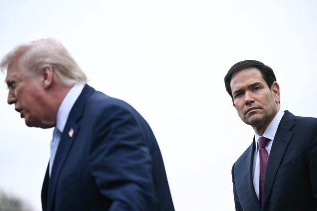 US Secretary of State Marco Rubio looks on as US President Donald Trump speaks to journalists before boarding Marine One as he departs from the South Lawn of the White House in Washington, DC, on March 20, 2026 for his Mar-a-Lago residence, where he will spend the weekend. (Photo by Brendan SMIALOWSKI / AFP)