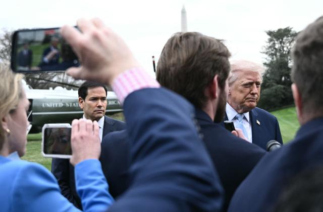 US Secretary of State Marco Rubio looks on as US President Donald Trump speaks to journalists before boarding Marine One as he departs from the South Lawn of the White House in Washington, DC, on March 20, 2026 for his Mar-a-Lago residence, where he will spend the weekend. (Photo by Brendan SMIALOWSKI / AFP)