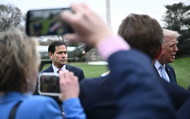 US Secretary of State Marco Rubio looks on as US President Donald Trump speaks to journalists before boarding Marine One as he departs from the South Lawn of the White House in Washington, DC, on March 20, 2026 for his Mar-a-Lago residence, where he will spend the weekend. (Photo by Brendan SMIALOWSKI / AFP)