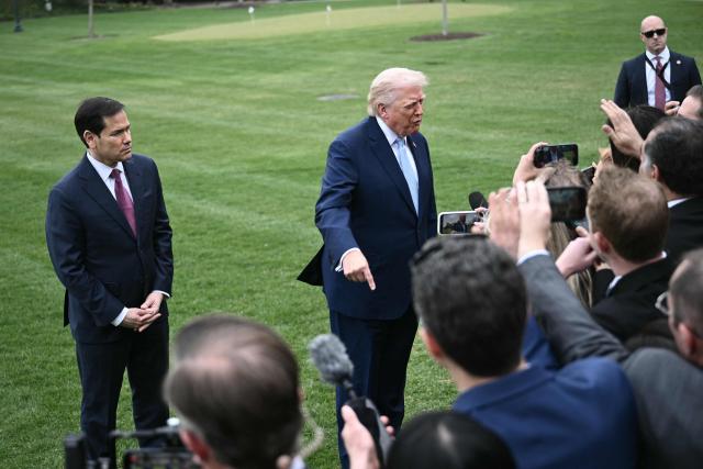 US Secretary of State Marco Rubio looks on as US President Donald Trump speaks to journalists before boarding Marine One as he departs from the South Lawn of the White House in Washington, DC, on March 20, 2026 for his Mar-a-Lago residence, where he will spend the weekend. (Photo by Brendan SMIALOWSKI / AFP)