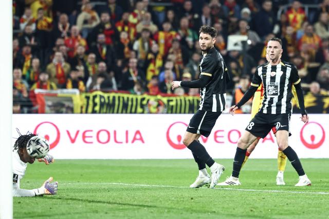 Angers' Dutch midfielder #08 Branco Van Den Boomen (R) and Angers' French defender #21 Jordan Lefort (C) eye the ball as Lens' French forward #10 Florian Thauvin (rear hidden) scores his team's first goal during the French L1 football match between RC Lens and SCO Angers at the Stade Bollaert-Delelis in Lens, northern France, on March 20, 2026. (Photo by Sameer Al-DOUMY / AFP)