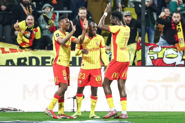 Lens' Malian midfielder #08 Mamadou Sangare (L) celebrates with Lens' Saudi Arabian defender #23 Saud Abdulhamid (C) and Lens' French forward #11 Odsonne Edouard after scoring his team's third goal during the French L1 football match between RC Lens and SCO Angers at the Stade Bollaert-Delelis in Lens, northern France, on March 20, 2026. (Photo by Sameer Al-DOUMY / AFP)