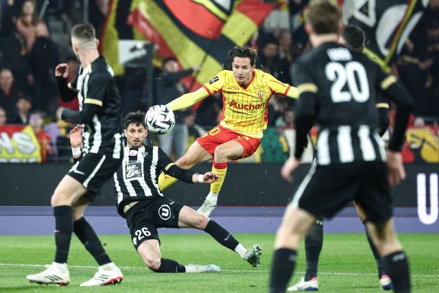 Lens' French forward #10 Florian Thauvin (C) kicks the ball next to Angers' French defender #26 Florent Hanin (L) during the French L1 football match between RC Lens and SCO Angers at the Stade Bollaert-Delelis in Lens, northern France, on March 20, 2026. (Photo by Sameer Al-DOUMY / AFP)