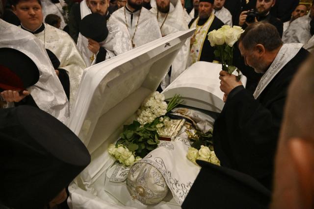 Clergymen and worshippers pay last respect for the late Patriarch Filaret in St. Michael’s Golden-Domed Cathedral in Kyiv on March 20, 2026, amid the Russian invasion of Ukraine. Patriarch Filaret was a central player in establishing an independent Ukrainian Church in the 1990s, breaking from the Russian Church, which has become increasingly entwined with the Kremlin and supports Russia's war on Ukraine. (Photo by Genya SAVILOV / AFP)