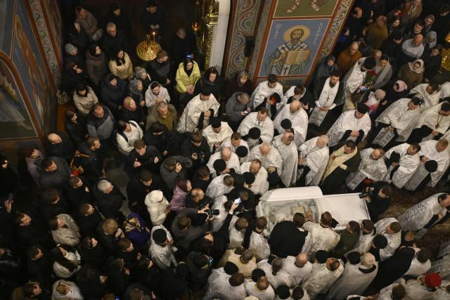 Clergymen and worshippers pay their last respects for the late Patriarch Filaret in St. Michael’s Golden-Domed Cathedral in Kyiv on March 20, 2026, amid the Russian invasion of Ukraine. Patriarch Filaret was a central player in establishing an independent Ukrainian Church in the 1990s, breaking from the Russian Church, which has become increasingly entwined with the Kremlin and supports Russia's war on Ukraine. (Photo by Genya SAVILOV / AFP)
