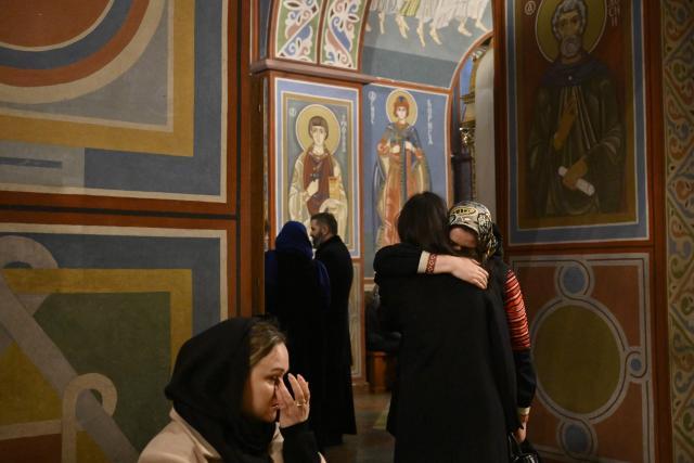 Attendees mourn during a farewell ceremony for the late Patriarch Filaret in St. Michael’s Golden-Domed Cathedral in Kyiv on March 20, 2026, amid the Russian invasion of Ukraine. Patriarch Filaret was a central player in establishing an independent Ukrainian Church in the 1990s, breaking from the Russian Church, which has become increasingly entwined with the Kremlin and supports Russia's war on Ukraine. (Photo by Genya SAVILOV / AFP)