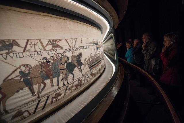 (FILES) People look at the "Bayeux tapestry" or "Queen Mathilde tapestry" which relates England's conquest by William the Conqueror (Guillaume le Conquerant) in 1066, in Bayeux, western France, on September 13, 2019. King Harold's legendary 200-mile march across England to the Battle of Hastings in 1066 is a "myth" that likely never happened, according to research published March 21, 2026. Ahead of the tapestry's exhibition at the British Museum starting in September 2026. New research from the University of East Anglia (UEA) revealed the account of the march as taught in British classrooms and museums, rests on what a UAE historian argues is a misinterpretation of the Anglo-Saxon Chronicle. (Photo by LOIC VENANCE / AFP)