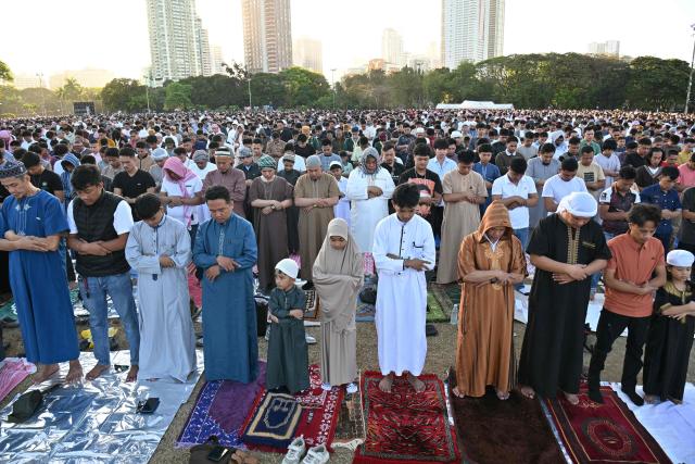 Muslim devotees take part in a morning prayer celebrating Eid al-Fitr, which marks the end of the holy month of Ramadan, in front of the Quirino grandstand in Manila on March 21, 2026. (Photo by Ted ALJIBE / AFP)