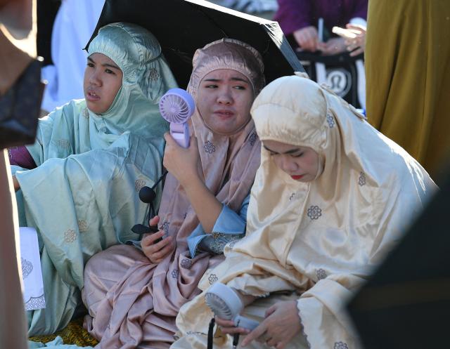 Muslim devotees take part in a morning prayer celebrating Eid al-Fitr, which marks the end of the holy month of Ramadan, in front of the Quirino grandstand in Manila on March 21, 2026. (Photo by Ted ALJIBE / AFP)