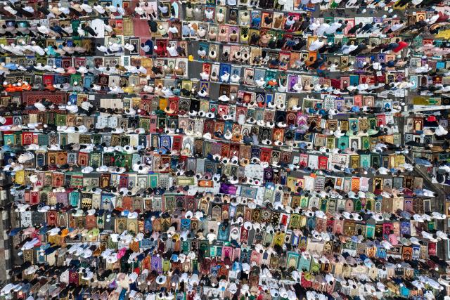 This aerial picture shows Muslim devotees attending Eid al-Fitr prayers, marking the end of the holy month of Ramadan, in Jakarta on March 21, 2026. (Photo by BAY ISMOYO / AFP)